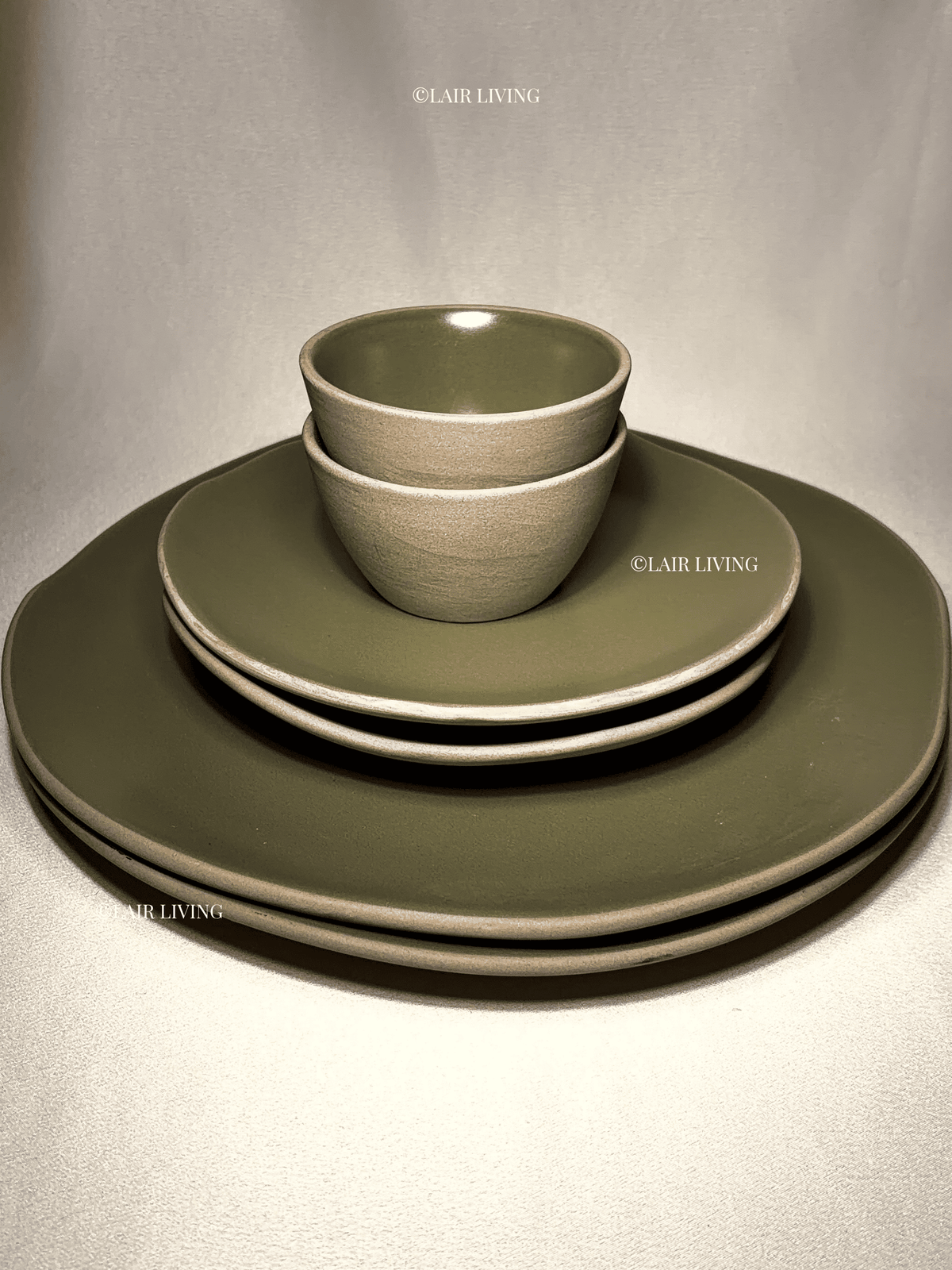 Stacked Verdant matte olive stoneware place setting: full plates, quarter plate, katori and small bowl — Lair Living